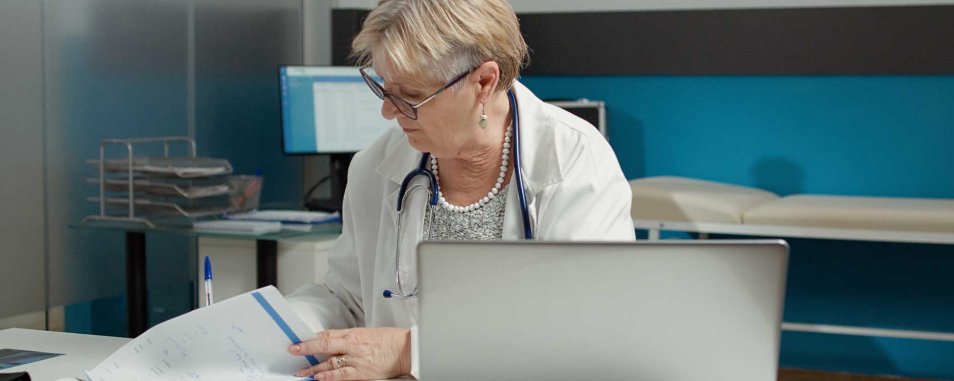 Female healthcare professional reviewing documents at her desk, representing medical billing companies in San Antonio, TX.